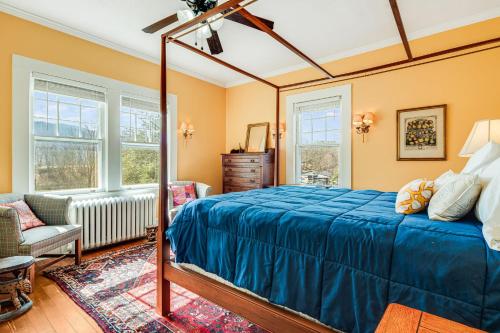 a bedroom with a bed and a couch and windows at Prospect Hill on Main in Waynesville