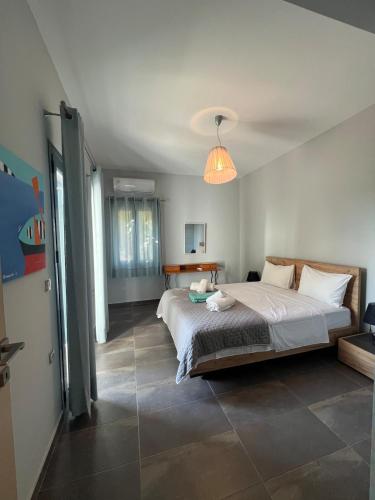a bedroom with a large bed and a pendant light at Pebble Home in Yialós