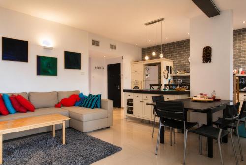 a living room and kitchen with a couch and a table at Carmel Home Mount Seaview in Haifa