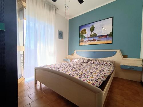 a bedroom with a bed and a painting on the wall at Condominio Aquila in Bibione