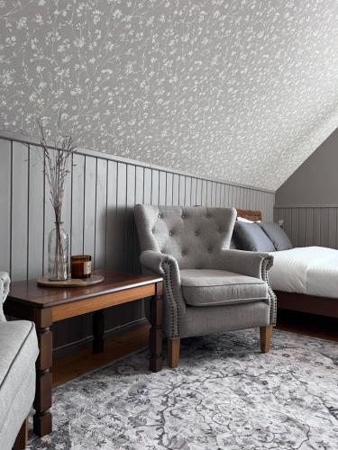 a bedroom with a bed and a couch and a chair at 2ÕDE Kodumajutus in Hullo
