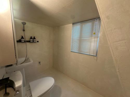a bathroom with a white toilet and a window at Lagom villiage in Paegun-dong