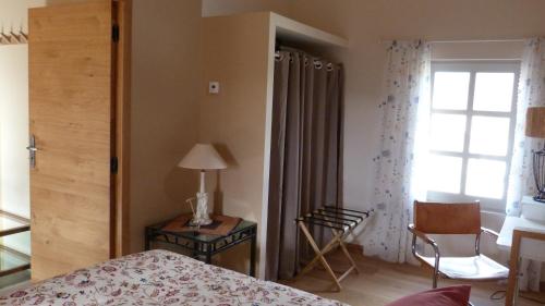 a bedroom with a bed and a chair and a window at Mas des Treilles - Chambre d'hôtes - Côté Campagne in Mane