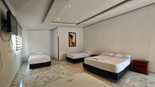 a hotel room with two beds and a tv at Hotel El Principe in Ocaña