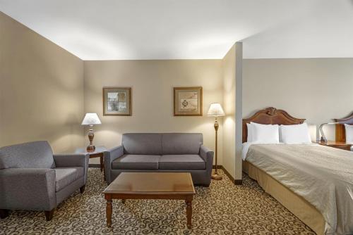 a hotel room with a bed and two chairs at Best Western PLUS Fossil Country Inn & Suites in Kemmerer