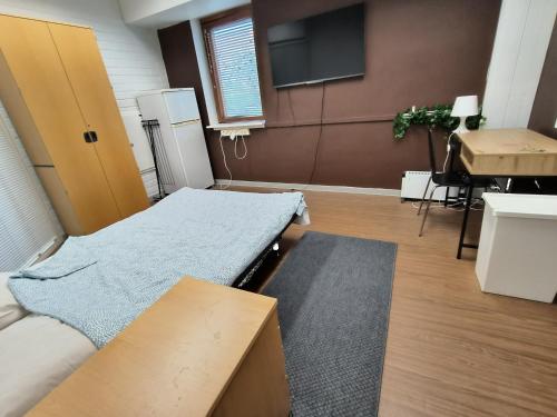 a room with a bed and a table and a sink at Office House Tripla in Helsinki
