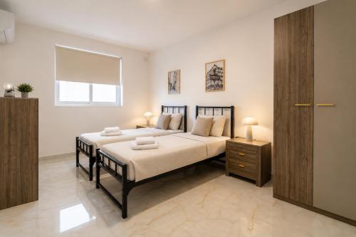 a bedroom with a large bed and a wooden cabinet at Three Bedroom Qormi Home in Santa Venera