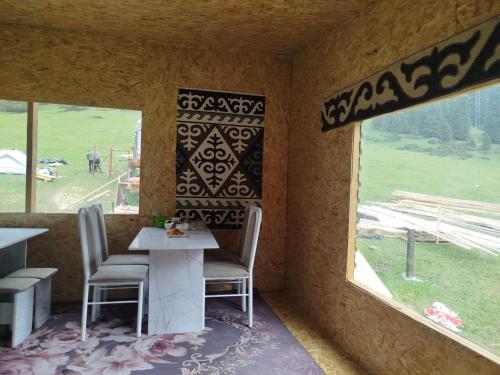 a room with two chairs and a table and a window at Kyrgyz Yurt Camp in Mineralʼnyy Istochnik Altyn-Arasan