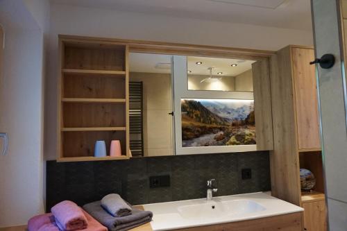 a bathroom with a sink and a mirror at Komfort Appartements Talbach in Hippach