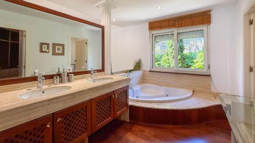 a large bathroom with two sinks and a tub at Villa Terramar by Hello Homes Sitges in Sitges