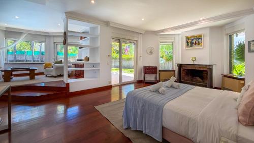 a bedroom with a large bed and a fireplace at Villa Terramar by Hello Homes Sitges in Sitges