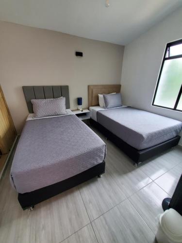 a bedroom with two beds and a window at Envigado tradicion y modernidad in Envigado