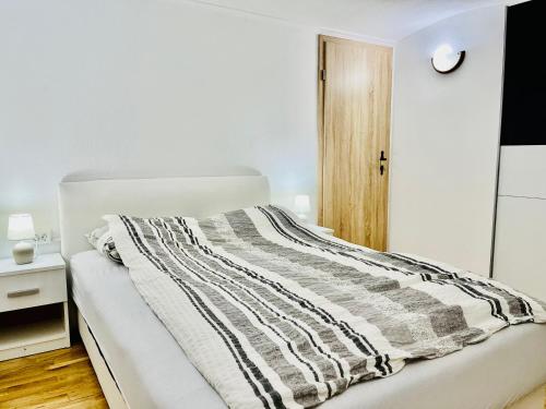 a bedroom with a bed with a striped blanket on it at Apartma Elza in Tržič