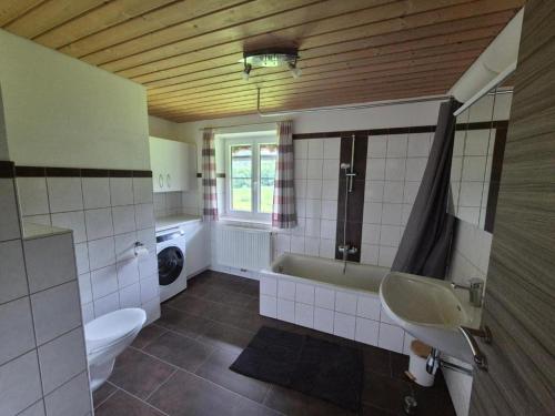 a bathroom with a tub and a toilet and a sink at Urlauben im Grünen in Fuschl am See