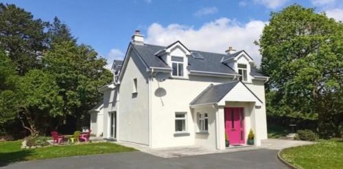 a white house with a red door at Atlantic Way Cottage - Peaceful Connemara Retreat Near Aran Islands in Galway