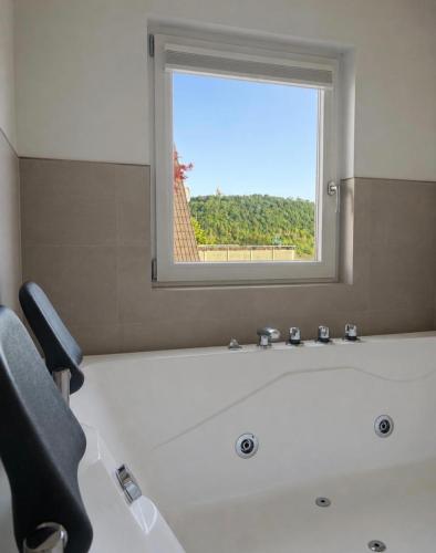 a bathroom with a bath tub with a window at Ferienhäuschen mit Wellnessbereich in Marsberg