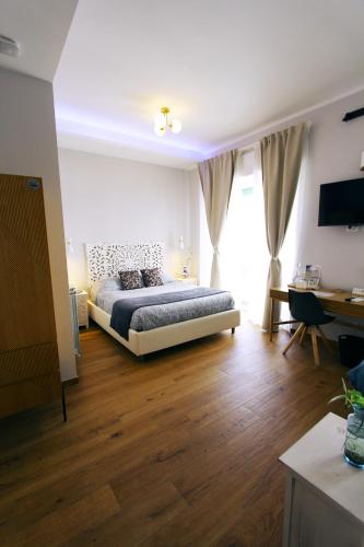 a bedroom with a bed and a desk in a room at La Dolce Vita Civitavecchia in Civitavecchia