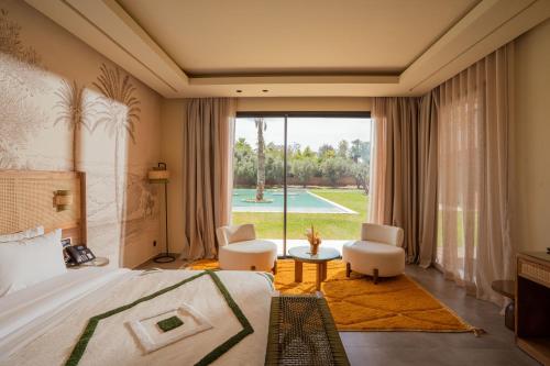 a bedroom with a bed and a view of a pool at Palais Zaitunay in Marrakesh