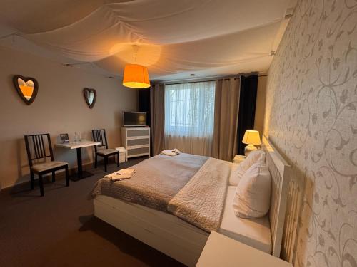 a bedroom with a bed and a table and chairs at Dworek in Szonowice