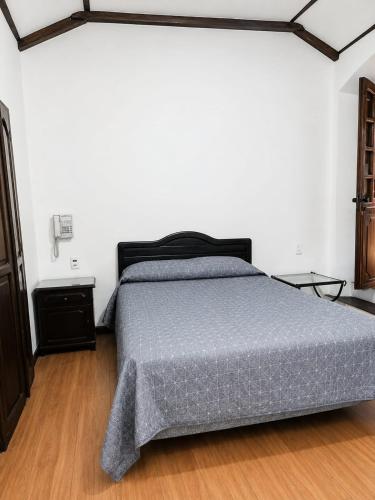 a bedroom with a bed with a gray comforter at B&B Recoleta in Sucre