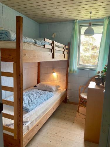 a bedroom with two bunk beds and a window at Sommerhuset i Saltum in Saltum