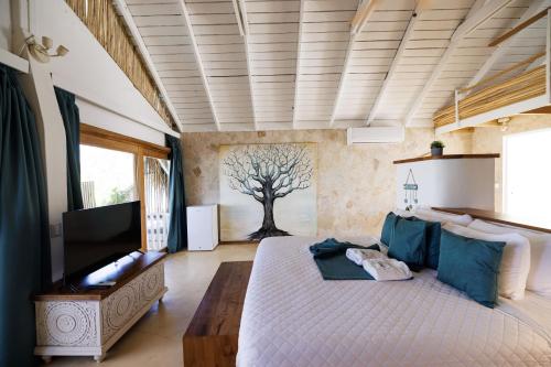 a bedroom with a large bed and a tree mural at El Mosquito Boutique Hotel Playa Bonita in Las Terrenas