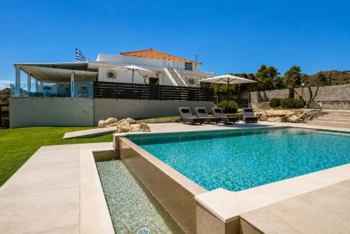 a swimming pool in front of a house at AVENTINE - Luxury Residences with Private Pools in Kalithies