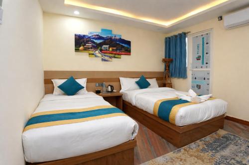 a hotel room with two beds and a window at Hotel Kusum Palace in Kathmandu