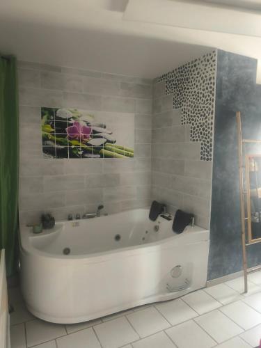 a white bath tub in a bathroom with a painting at Emplacement de tente in Hardinghen