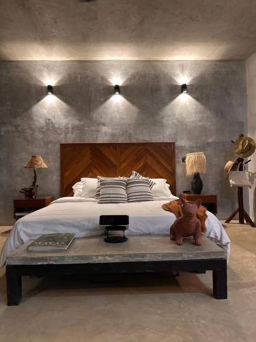 a bedroom with a bed with a teddy bear sitting on a table at Aldea Pukna Tulum in Akumal