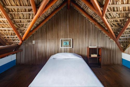 a bedroom with a large bed in a bamboo wall at Punta Dreams in Brisas de Zicatela