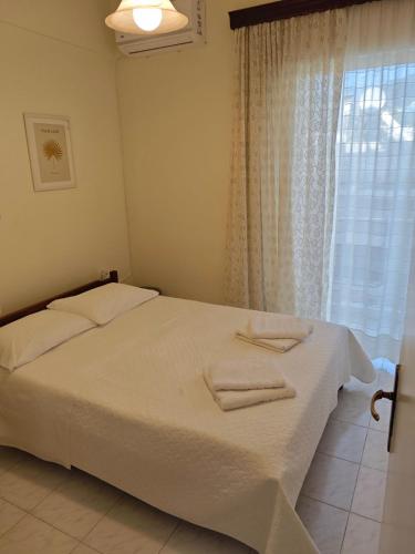 a bedroom with a bed with two towels on it at Mary's Home in Kalamata
