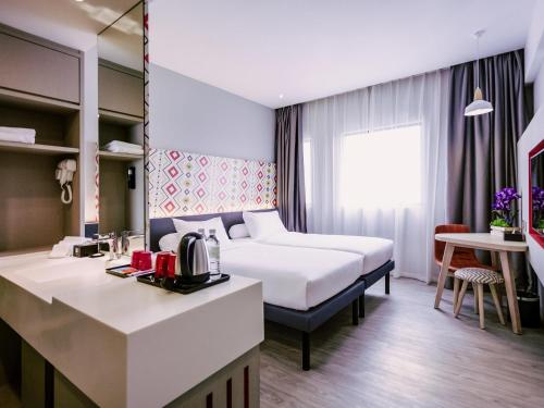 a hotel room with a bed and a kitchen at ibis Styles Kota Bharu in Kota Bharu