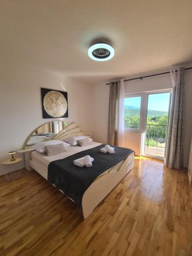 a bedroom with a large bed and a large window at Kuća za odmor Virgo in Opanci