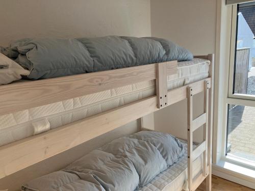 two bunk beds in a room with a window at Havrevang Lønstrup, Ferielejligheder in Lønstrup