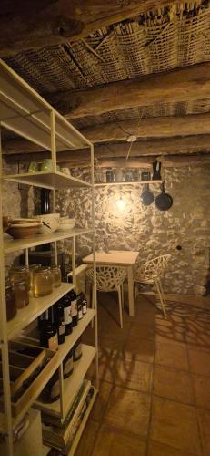 a kitchen with a table and a shelf with wine bottles at Casa Utopia in Miravet