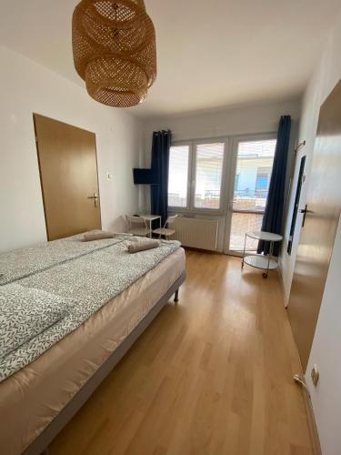 a bedroom with a bed and a large window at Baltic Garden Stay in Kołobrzeg