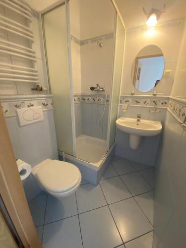 a bathroom with a toilet a sink and a shower at Baltic Garden Stay in Kołobrzeg
