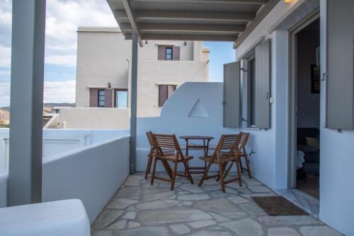 a patio with chairs and a table on a balcony at Easy Living Tinos in Vrachonisída Chántra