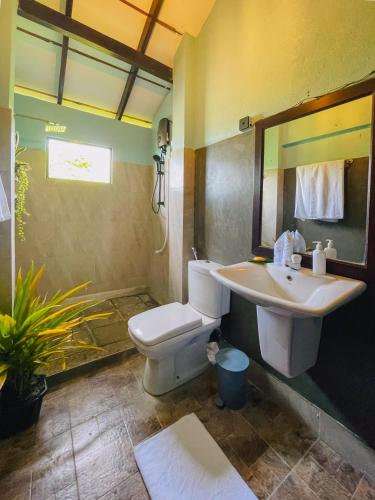 a bathroom with a toilet and a sink at Turtle Breeze Rekawa in Tangalle