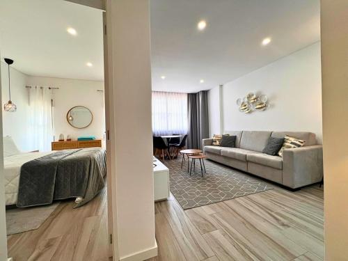a bedroom and a living room with a bed and a couch at Timeless Beach V - Apartment in Armação de Pêra