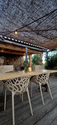 a table and benches on a deck with a roof at Casa Utopia in Miravet