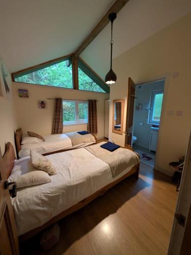 a bedroom with two beds and a large window at Loch Aweside Forest Cabins in Dallavich
