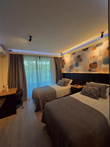 a hotel room with two beds and a window at Hotel LUHA in Puerto Varas