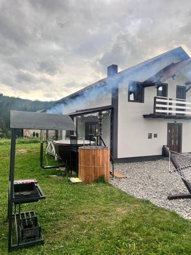 a white house with smoke coming out of it at Лайт Хайс Буковель in Palyanytsya
