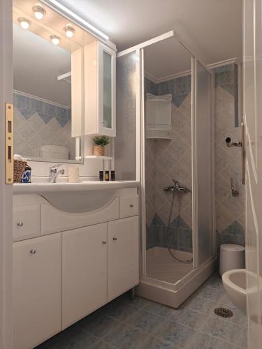 a white bathroom with a shower and a sink at The View in Souvala