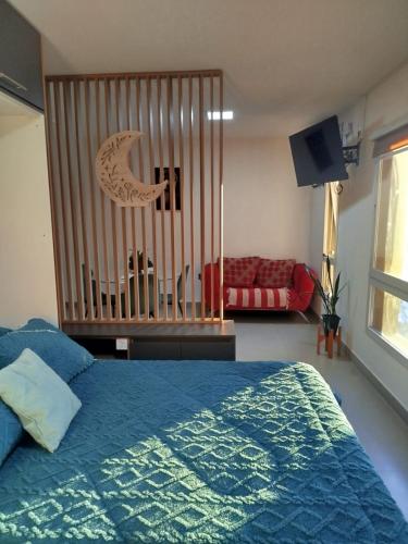 a crib in a bedroom with a blue bed at Departamento moderno - Centro de San Luis in San Luis