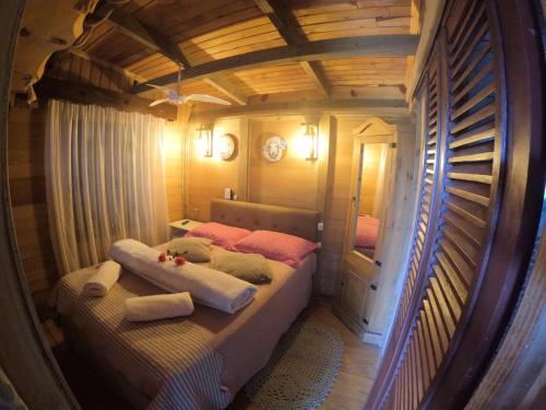 a bedroom with two beds in a room with a wooden ceiling at Chalé Cafofo in Campo Alegre