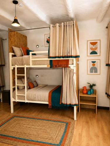 two bunk beds in a room with a rug at Terra House Hostel in Cusco