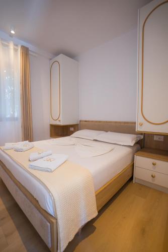 a bedroom with a large bed with two towels on it at Hotel by Jon in Dhërmi